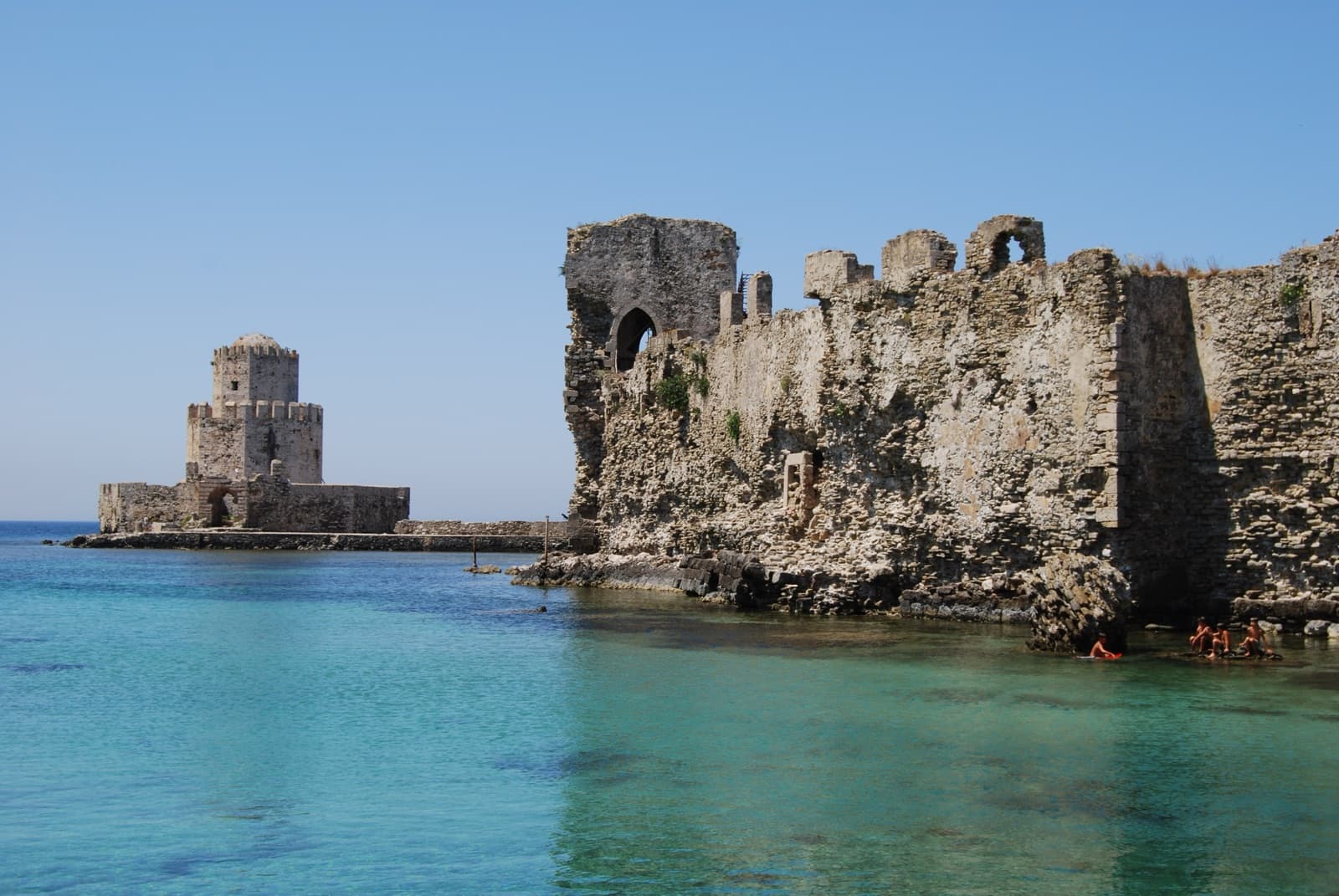 The Bourtzi tower and fortress walls of Methoni Castle meeting the Ionian Sea